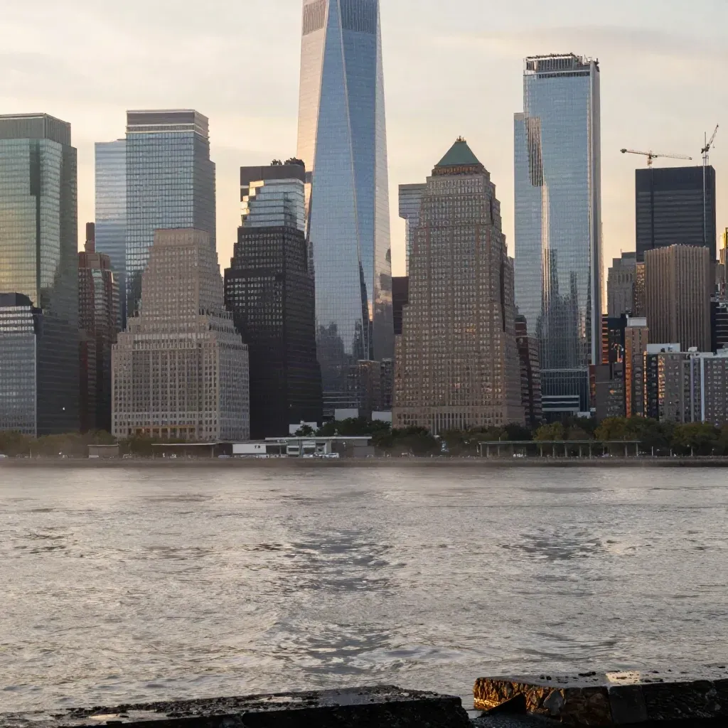 Manhattan skyline at amber sunset over the East River with Brooklyn in front and storm haze